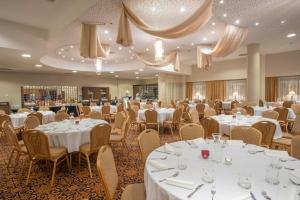 - une salle de banquet avec des tables et des chaises blanches dans l'établissement Spa Resort Tree of Life, à Lázně Bělohrad