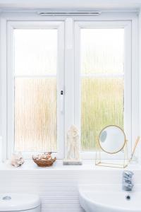 a white bathroom with a sink and a window at TravelNest Property in Bristol