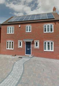 una casa de ladrillo con paneles solares en el techo en TravelNest Property en Bristol