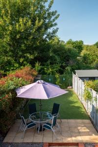 a patio with a table and chairs and an umbrella at TravelNest Property in Bristol