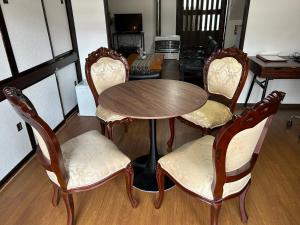 a wooden table and four chairs and a table and a kitchen at Cool-Residence OTARU in Otaru