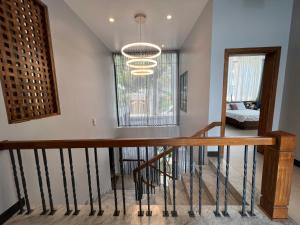 a staircase in a house with a chandelier at Nancy Grand Vung Tau Villa in Vung Tau