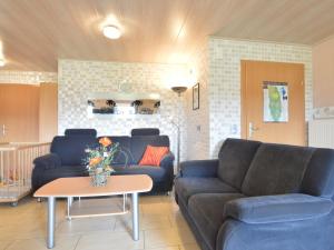 un soggiorno con 2 divani e un tavolo di Comfy Holiday Home in Burg Reuland with Sauna Terrace BBQ a Burg-Reuland