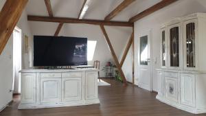 a living room with a tv on a white cabinet at SeenSucht & Urlaubsträume, Ferienwohnung "Seeadler" in Großräschen