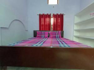 a bed with pink and purple sheets in a room at OYO Home Anjaneya Guest House Homestay in Ayodhya