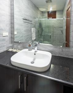 y baño con lavabo y ducha acristalada. en Kalipay Resort Siargao, en General Luna