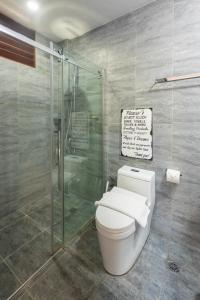 uma casa de banho com um WC e uma cabina de duche em vidro. em Kalipay Resort Siargao em General Luna