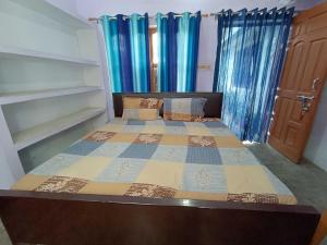 a bedroom with a bed with a quilt on it at OYO Home Anjaneya Guest House Homestay in Ayodhya