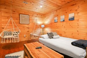 a log cabin with two beds and a swing at Relaxing Cabin near Bear Claw Vineyard, Hot Tub, Game Room, Pet Friendly, sleeps10 in Blue Ridge