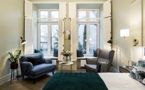 - une chambre avec un lit, 2 chaises et des fenêtres dans l'établissement Moja apartments, à Cracovie