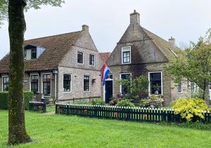 een huis met een vlag ervoor bij Bij Risje dorp in Ballum
