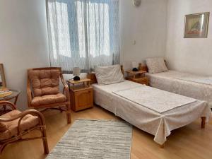 ein Wohnzimmer mit 2 Betten und einem Stuhl in der Unterkunft The Two Anchors in Nessebar