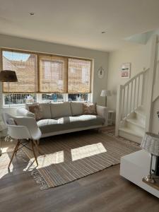 a living room with a couch and a chair at Paris Plage - volledig vernieuwd, free parking in Noordwijk aan Zee