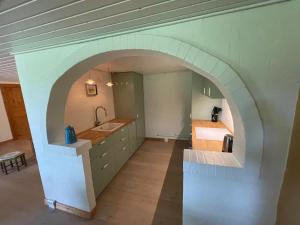 uma arcada numa cozinha com um lavatório e um balcão em Korsholt-natur 135 G em Sindal