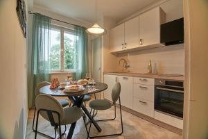 a kitchen with a table and chairs in a kitchen at Apartment Bigeste - free parking - 2 minute walk to the beach - superfast wifi in Opatija