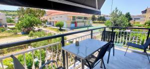 a table and chairs on a balcony with a view of a street at XD Central Apartments in Ierissos