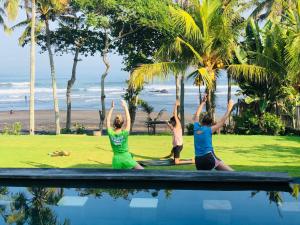 a group of people doing yoga on the beach at Bali Natha Beach Front in Canggu