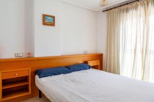 a bedroom with a bed with a wooden headboard and a window at Apolo66-3 in Torrevieja +16 photos
