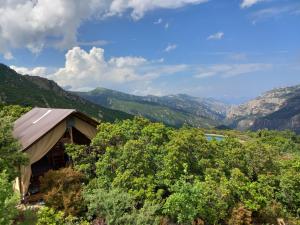 vistas a un valle con montañas y a una casa en Glamping tent nel Supramonte, en Urzulei