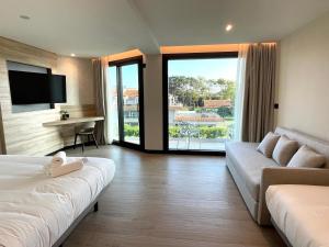 a hotel room with a couch and a tv at Hotel Delfin Azul in A Lanzada