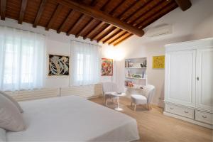a bedroom with a white bed and a desk and chairs at San Niccolò City Walls Garden in Florence