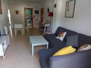 salon z niebieską kanapą i stołem w obiekcie Apartamento en zona Atalaya con garaje y WIFI w mieście Conil de la Frontera