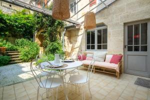 um pátio com uma mesa, cadeiras e um sofá em Appartement avec son patio dans centre historique de Bourg em Bourg-sur-Gironde