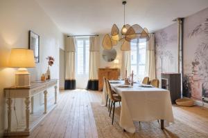 uma sala de jantar com uma mesa branca e cadeiras em Appartement avec son patio dans centre historique de Bourg em Bourg-sur-Gironde