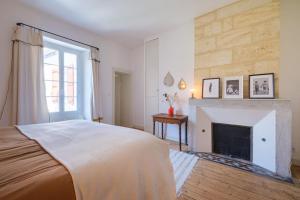 um quarto com lareira e uma cama grande em Appartement avec son patio dans centre historique de Bourg em Bourg-sur-Gironde