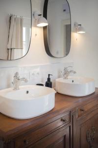 uma casa de banho com 2 lavatórios e um espelho em Appartement avec son patio dans centre historique de Bourg em Bourg-sur-Gironde