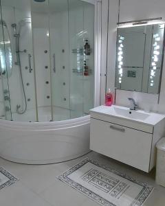 a white bathroom with a shower and a sink at Denize Sıfır 2 Yatak Odalı ve 2 Çekyatlı Bahçeli Ev - Seafront, 2 bedroom, 2 sofa bed house with big garden in Rize