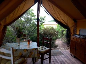 a table in a tent with a table and chairs at Glamping tent nel Supramonte in Urzulei