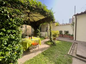 a table with a yellow table cloth sitting under an umbrella at San Niccolò City Walls Garden in Florence