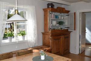 a kitchen with a table and a wooden cabinet at Vandrarhemmet Gammelgården in Bengtsfors