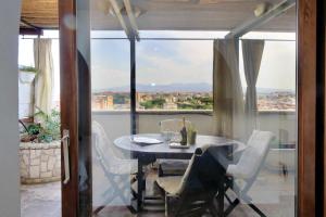 a table and chairs on a balcony with a view at Super Attico con terrazza Lodi in Rome