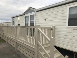 a mobile home with a porch and a deck at Hot Tub Accommodation North Wales Caravan in Rhyl
