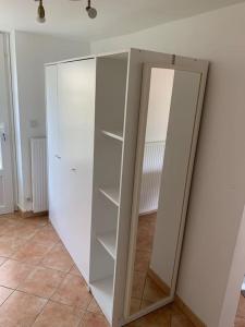 - Armario blanco con espejo en la habitación en Appartement proche Saint Malo, en Saint-Jouan-des-Guérets