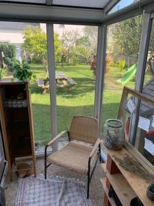 un porche cubierto con una silla y una mesa en Appartement proche Saint Malo, en Saint-Jouan-des-Guérets