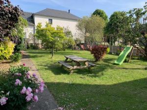 una mesa de picnic en un patio con un tobogán en Appartement proche Saint Malo, en Saint-Jouan-des-Guérets