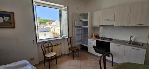 a kitchen with chairs and a sink and a window at Casa Giusto Ischia in Ischia Town