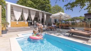 eine Frau und ein Kind auf einem Schlauch in einem Schwimmbad in der Unterkunft Polidor Camping Resort in Poreč