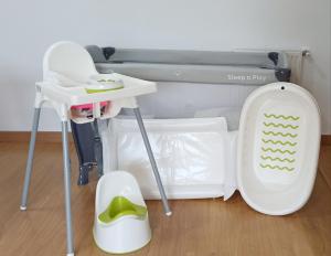 a baby crib with a table and a high chair at Apartamento PATXIKE con plaza de garaje in Bermeo