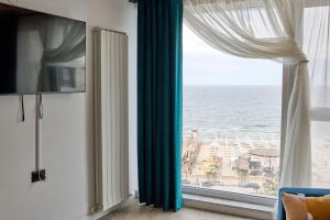 een kamer met een raam met uitzicht op de oceaan bij Cloud 9 Studio in Infinity Beach Resort in Mamaia