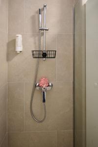 a shower with a hose in a bathroom at Cloud 9 Studio in Infinity Beach Resort in Mamaia