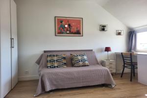 a bedroom with a bed and a picture on the wall at Studio Neuf Bien Agencé avec Ascenseur Port à 50M in Vannes