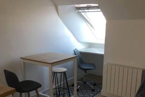 ein kleiner Tisch und Stühle in einem Zimmer mit Fenster in der Unterkunft Studio Très Agréable en Hyper Centre, 50 m du Port in Vannes