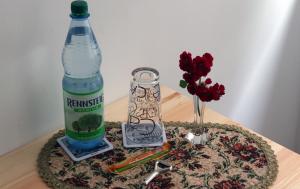 een fles water en bloemen op een tafel bij Gästezimmer zum rotem Karpfen in Erfurt