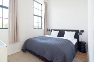 a bedroom with a bed and two windows at Cozy and Bright Apartments with Private Car Park in Copenhagen +89 photos