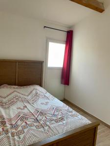 um quarto com uma cama com uma cortina vermelha em Cocon en Provence em Marignane