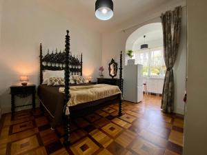 1 dormitorio con 1 cama y suelo de madera en Casa Anjos, en Coímbra